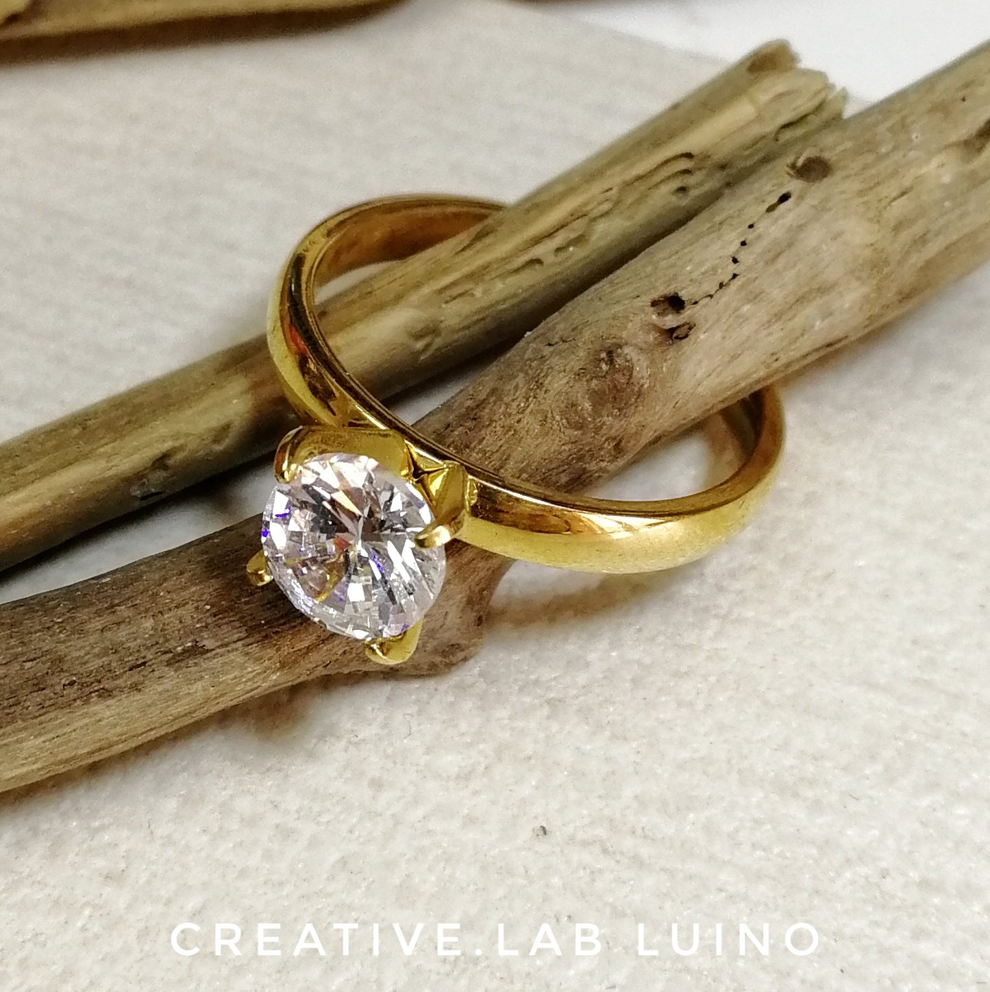 Anello in acciaio color oro con grande cristallo