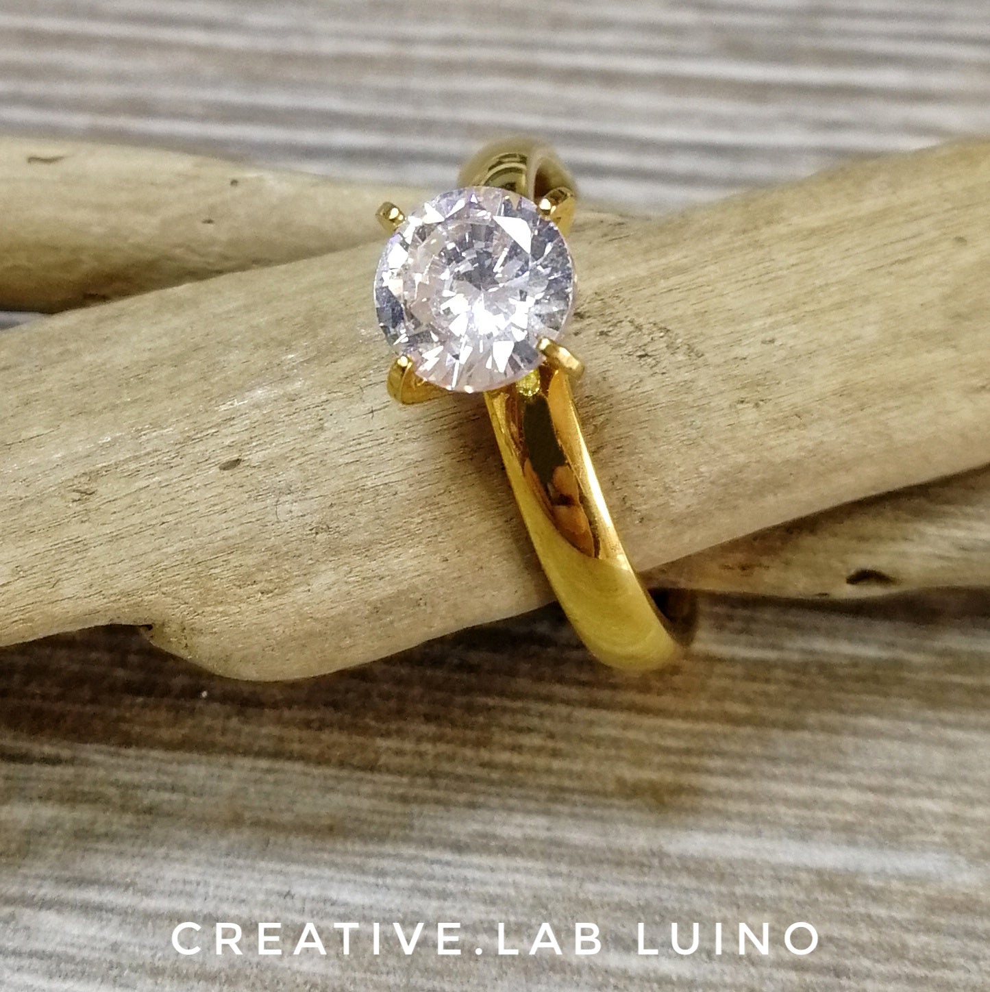 Anello in acciaio color oro con grande cristallo
